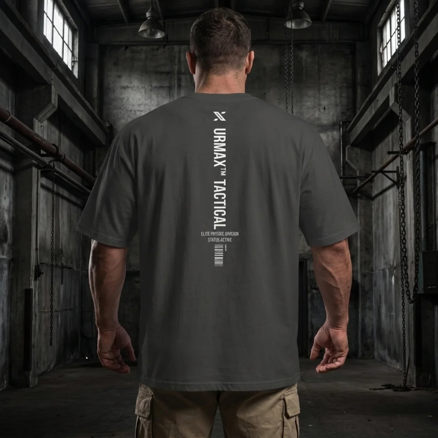 Man in an URMAX tactical oversized t-shirt standing in an industrial gym setting