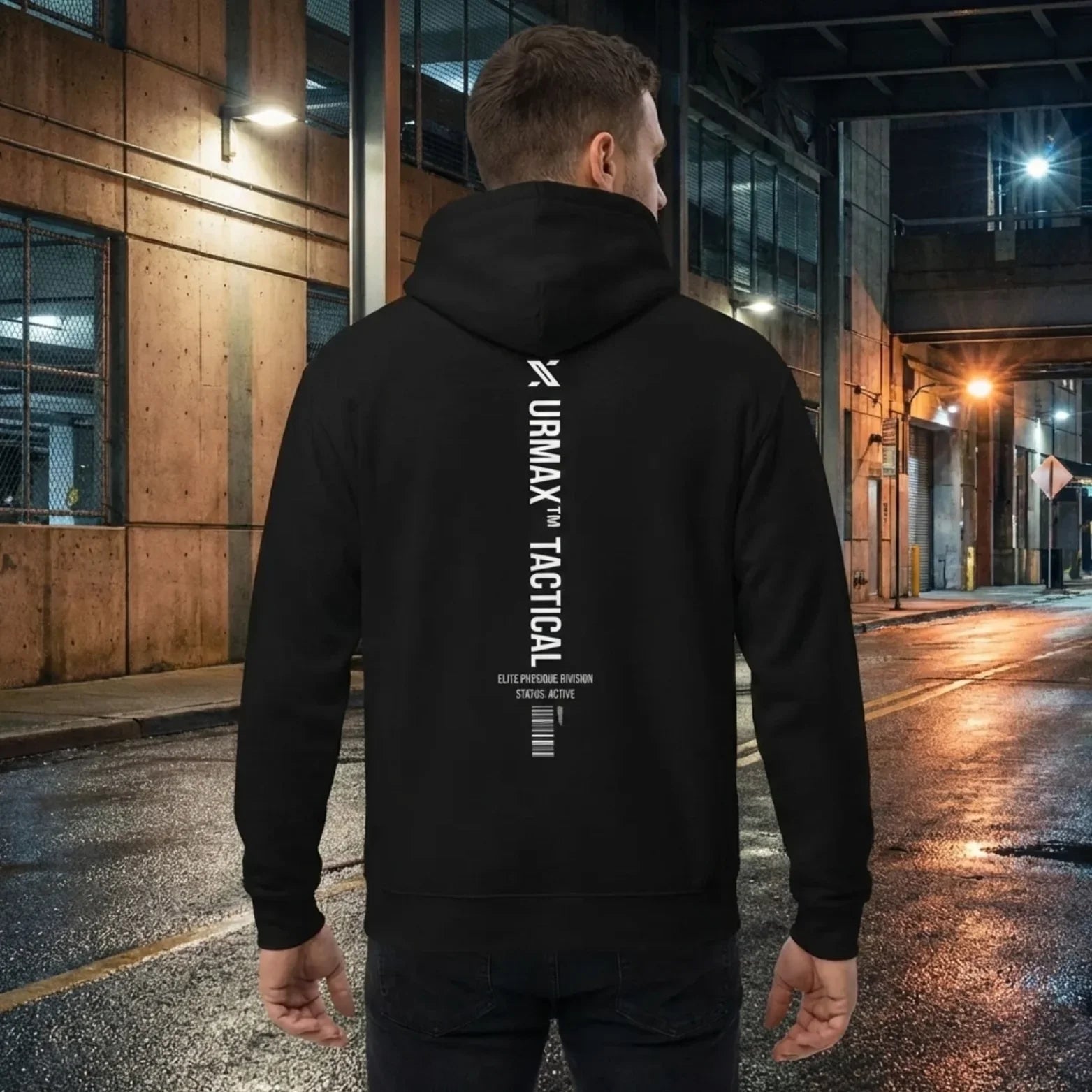 Man wearing black URMAX TACTICAL hoodie with bold white logo in urban night setting